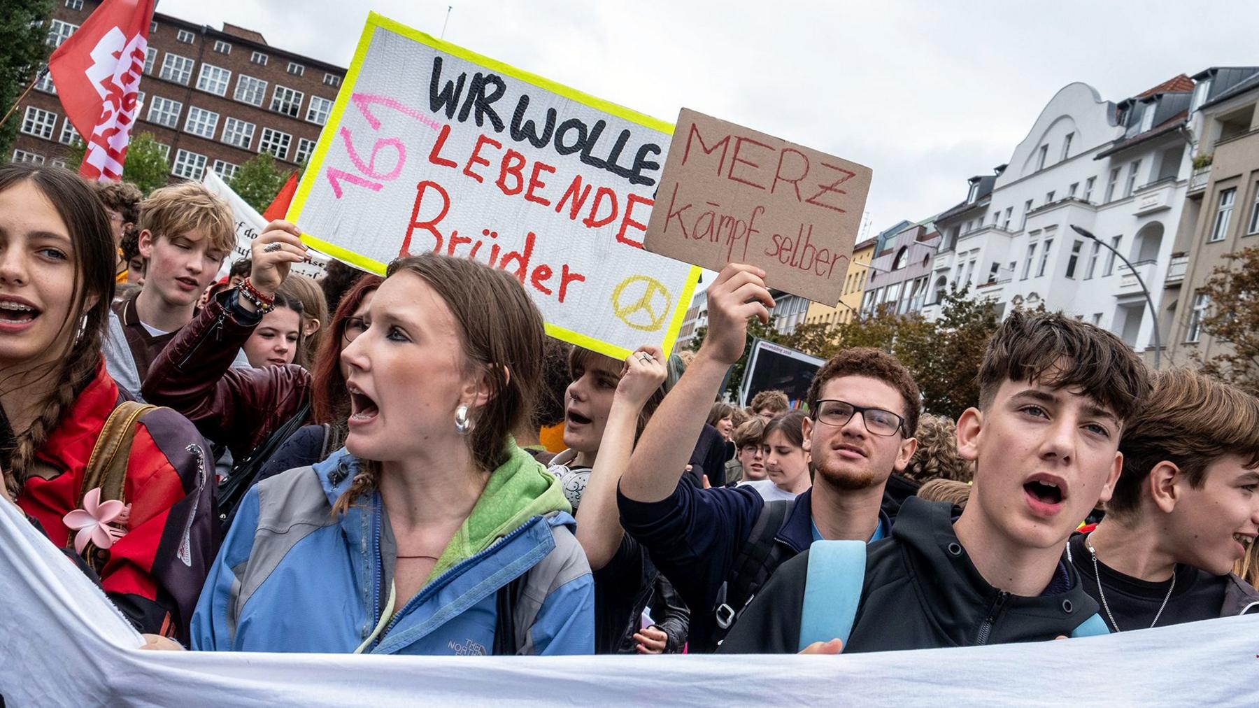 Germany students hold up several banners as they take part in a protest.