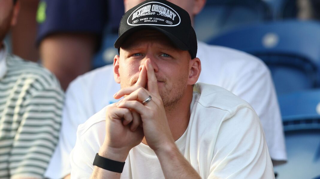 Aaron Ramsdale, wearing a black baseball cap and white t-shirt, watches Southampton's EFL Cup game at Colchester United from the stands