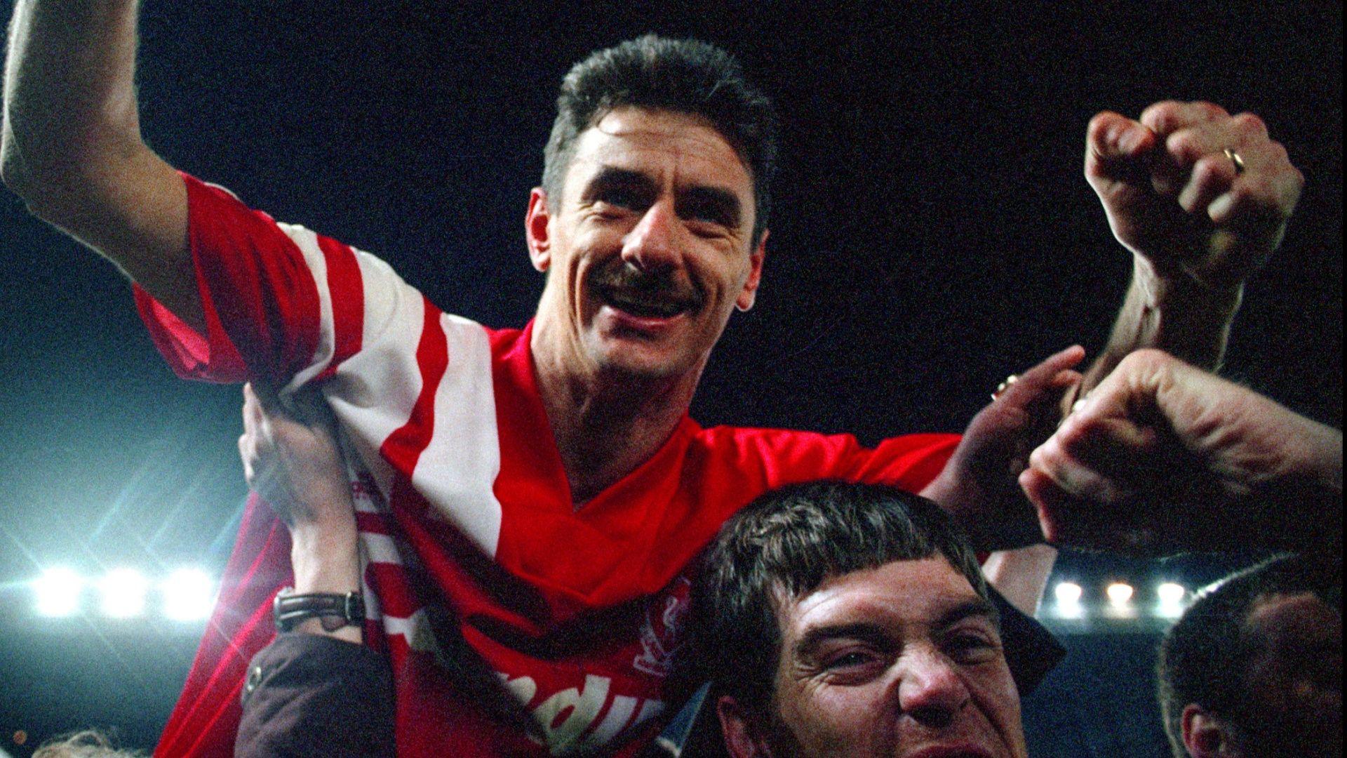 Ian Rush, in a red Liverpool kit, holds his arms aloft as he is carried by supporters off the pitch