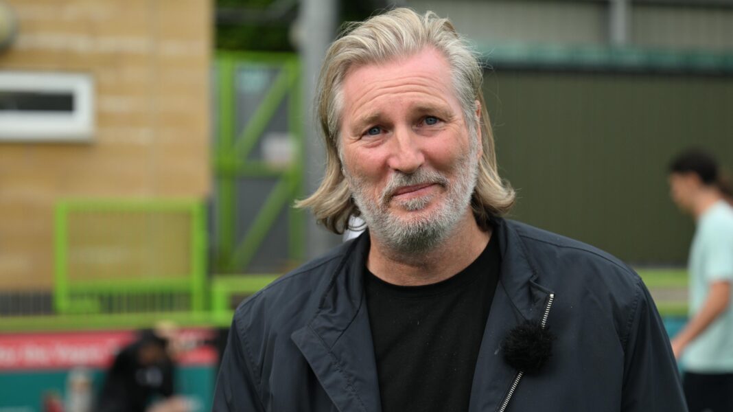 Robbie Savage wearing a black jacket and black top