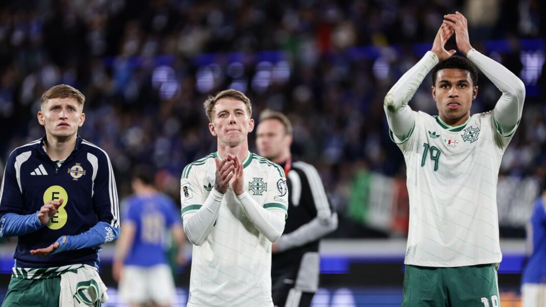 Callum Marshall, Ethan Galbraith and Shea Charles applaud the fans after Northern Ireland's play-off defeat by Italy.