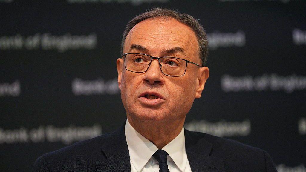 Governor of the Bank of England, Andrew Bailey, talks during a Bank of England Monetary Policy Report press conference. He is wearing a dark suit and tie.