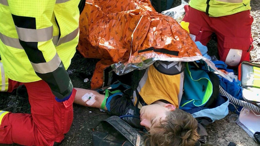 The handcyclist and model grabbing every opportunity after paralysis Callum Russell lies on a stretcher with two paramedics attending to him after crashing on his mountain bike