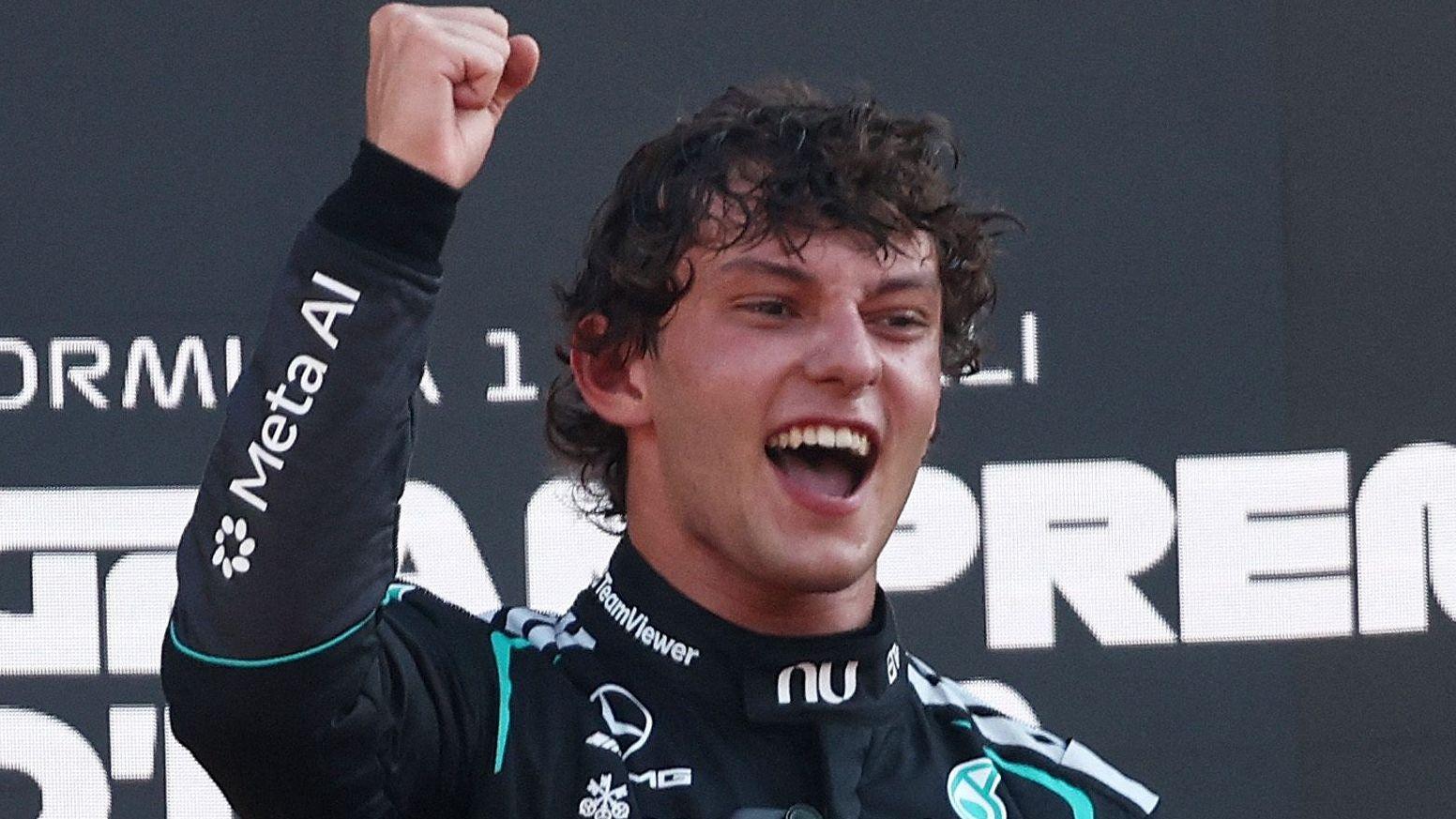 Kimi Antonelli smiles and clenches his right fist in celebration on the podium after winning the Italian Grand Prix