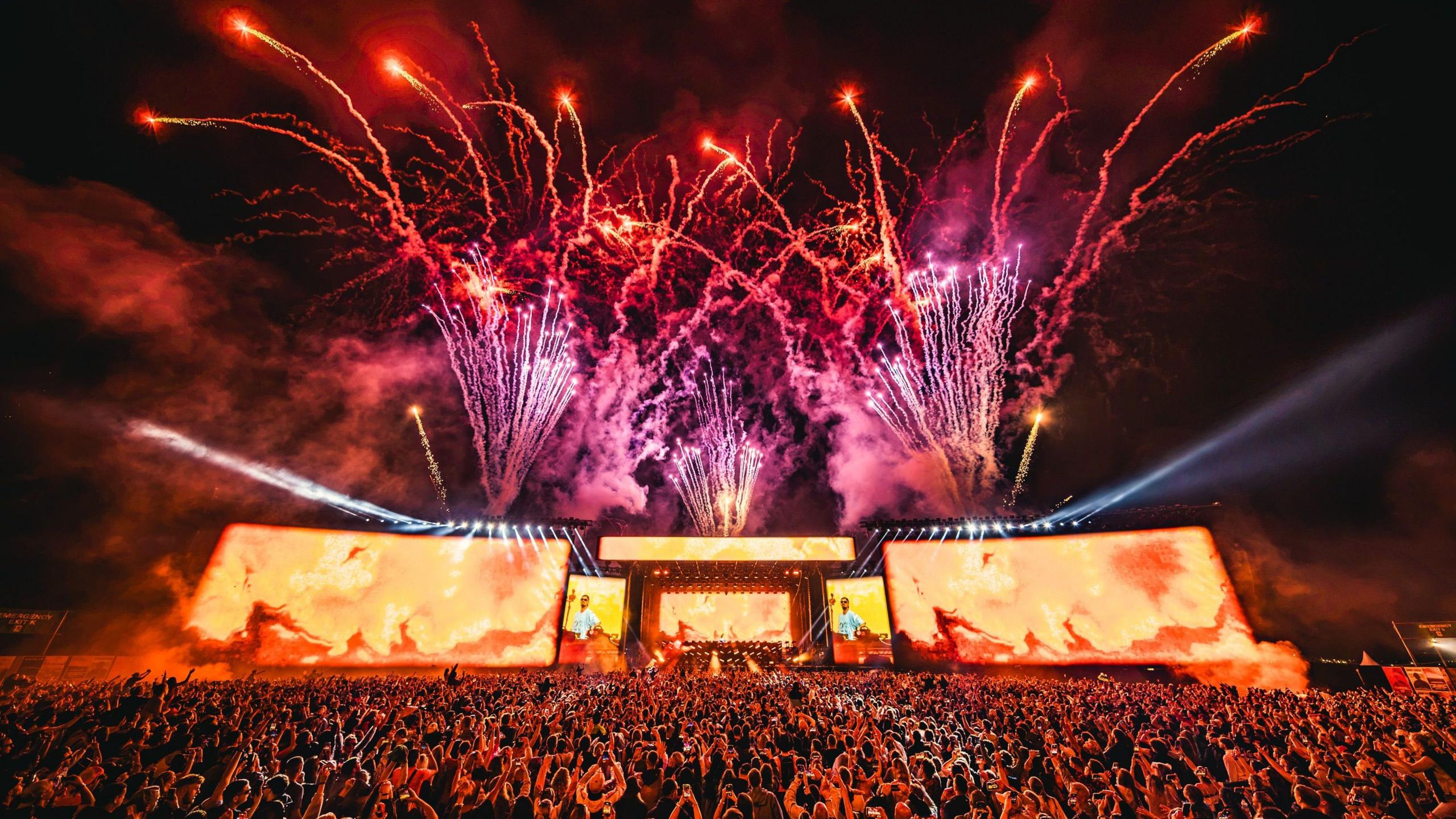 A wide shot of the main stage at Creamfields. It is nighttime and fireworks have been set off.