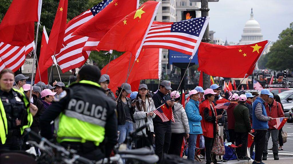 Police seen near protesters who wave flags with the US Capitol in the background
