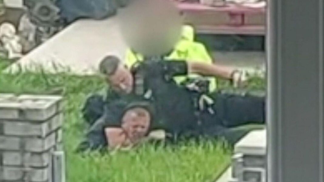 Police officer holding man to the ground in a garden