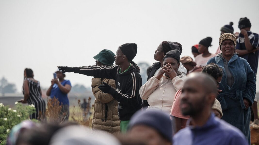 Ninth woman’s body found as South African police investigate string of deaths A group of people gathered near the site where the body was found. One woman is pointing