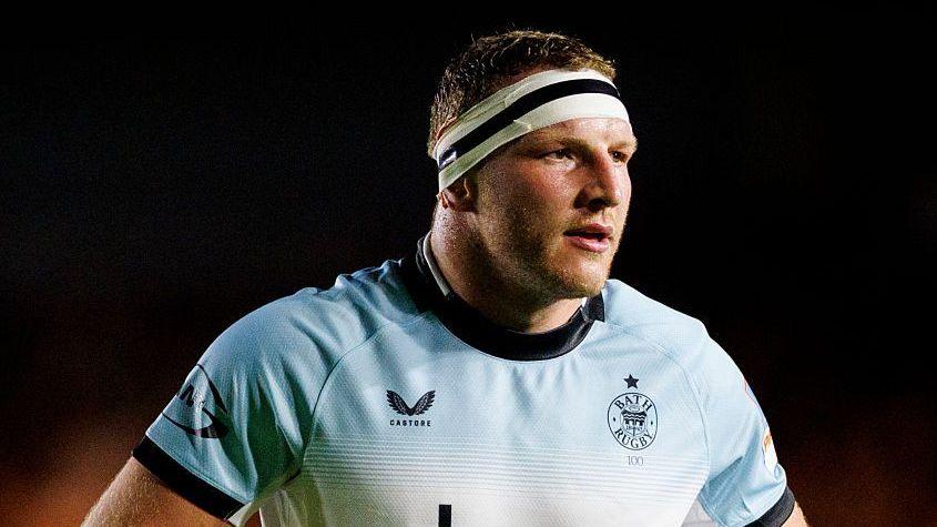Sam Underhill stands on the pitch wearing a light blue Bath away shirt, during their match against Harlequins