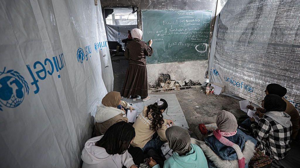 Palestinian girls listen during a lesson in a makeshift classroom at Jabalia refugee camp, in northern Gaza (4 April 2026)