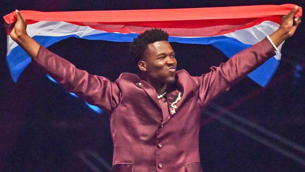 Dutch singer Claude representing the Netherlands with the song "C'est La Vie" parades with his national flag during the dress rehearsal for the final of the Eurovision Song Contest 2025 at the St. Jakobshalle arena in Basel on May 16, 2025