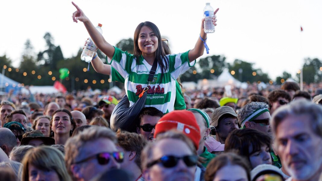 Pulp top the bill at 20th End of the Road Festival A woman sat on someone's shoulders smiling in a crowd of festival goers