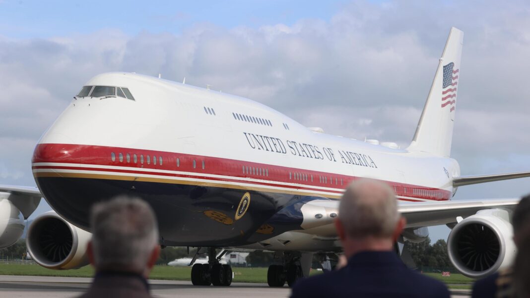 Air Force One on the tarmac in Ireland with blurred out people watching on.