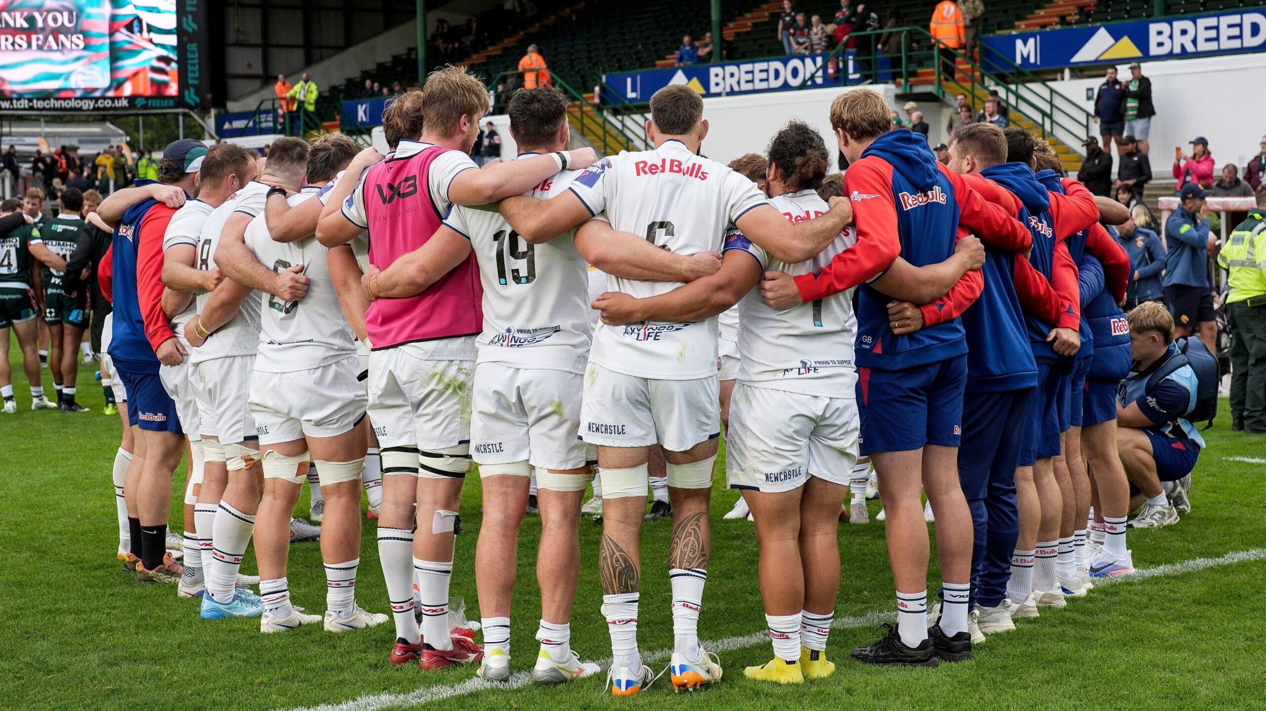 Newcastle players stand on the pitch in a huddle, with their backs to the camera, before a Prem Rugby Cup match in September 2026
