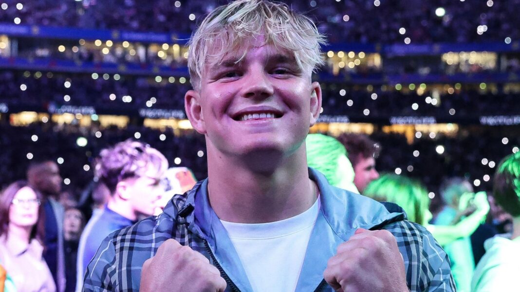 Pollock left money on table to stay at Saints – Hearn A smiling Henry Pollock is pictured in casual wear - white T-shirt and hooded top - with lights in the stands behind him as he attends Croke Park for Katie Taylor's final boxing fight