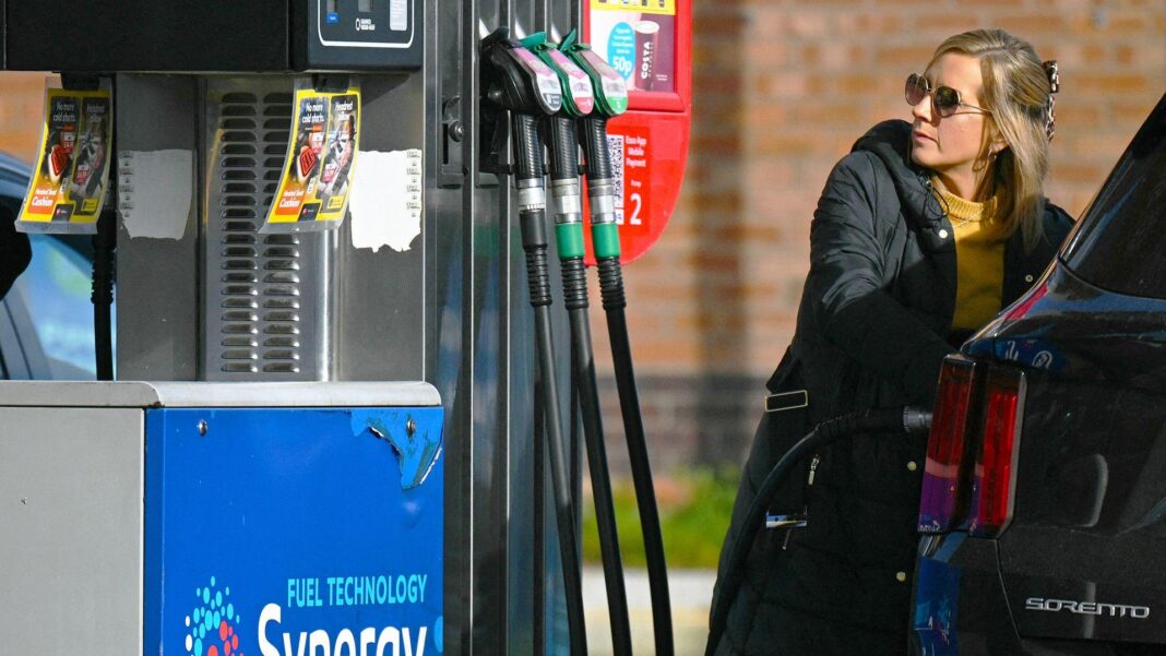 UK warned over ballooning debt costs and slower growth ahead of Budget A woman fills up her car with petrol