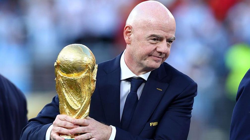 Gianni Infantino holding the World Cup trophy