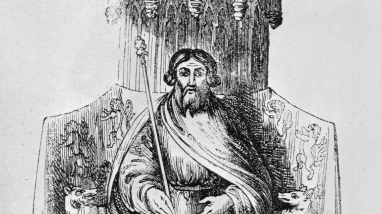 A black and white drawing of Owain Glyndŵr. He is sitting on a throne, wearing robes, and has a long beard.