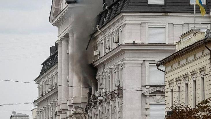 Black smoke pours from two windows in a large government building