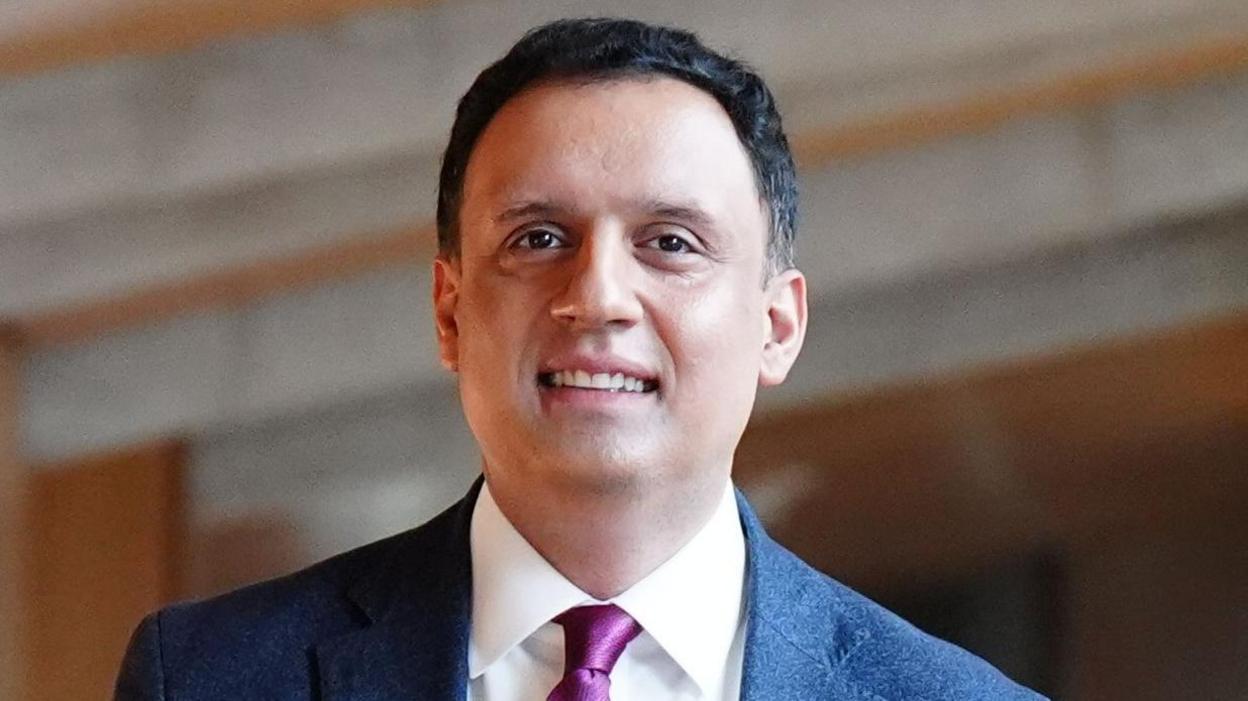 Anas Sarwar wears a dark suit and has short dark hair