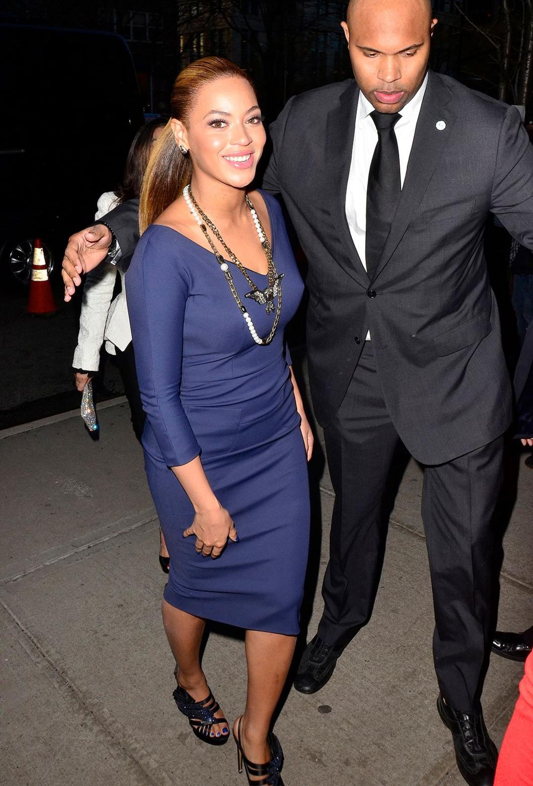 Beyoncé smiles and looks at camera while being led into a club in New York city in 2012.