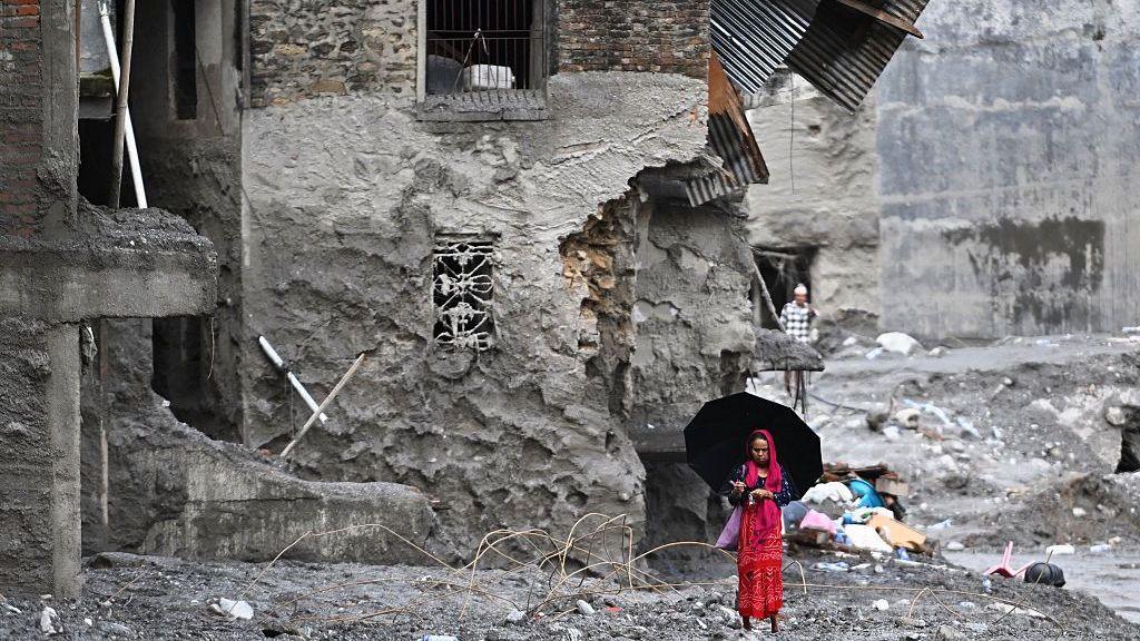 A woman walks among the ruins of flash floods in Nepal's Nuwakot district on September 1, 2026.