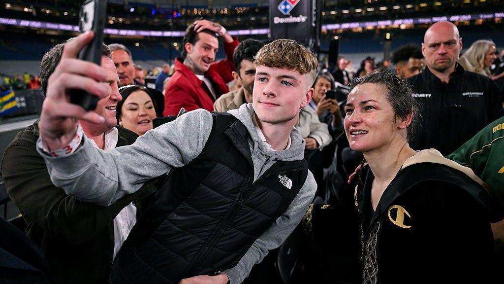 Katie Taylor takes a photo with a fan