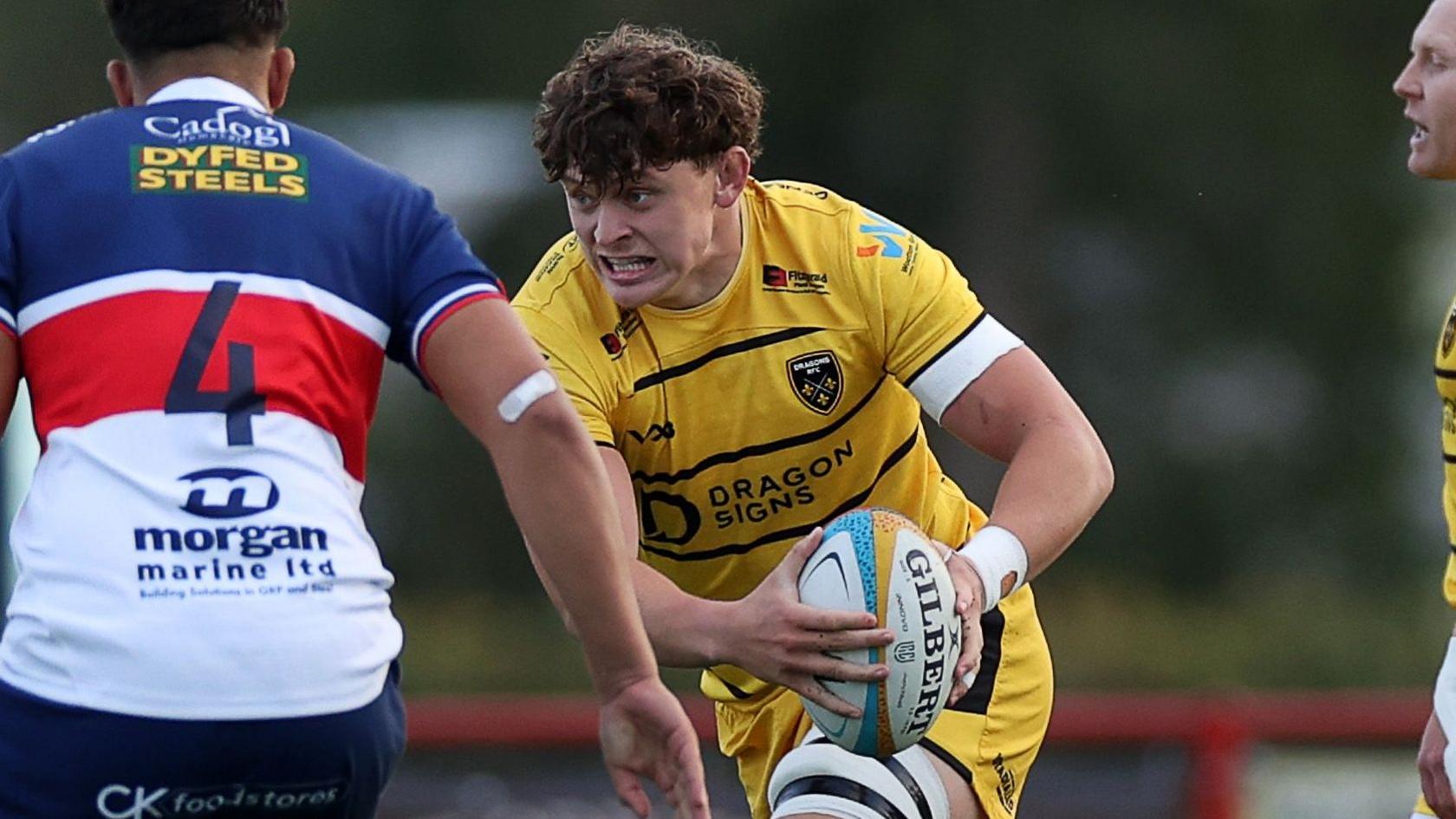 Ryan Woodman carries the ball in both hands for Dragons against Scarlets
