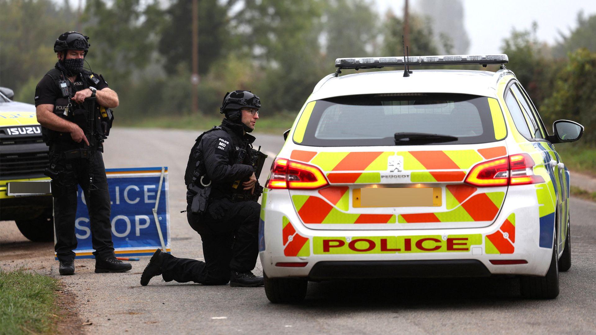 Police officers guard an area as roadblocks remain in place near RAF Fairford airbase, after police declared a major incident at the base and arrested several men on suspicion of offences under the Explosives Act, who have since been released on bail, in Fairford, Gloucestershire, Britain, September 29, 2026.