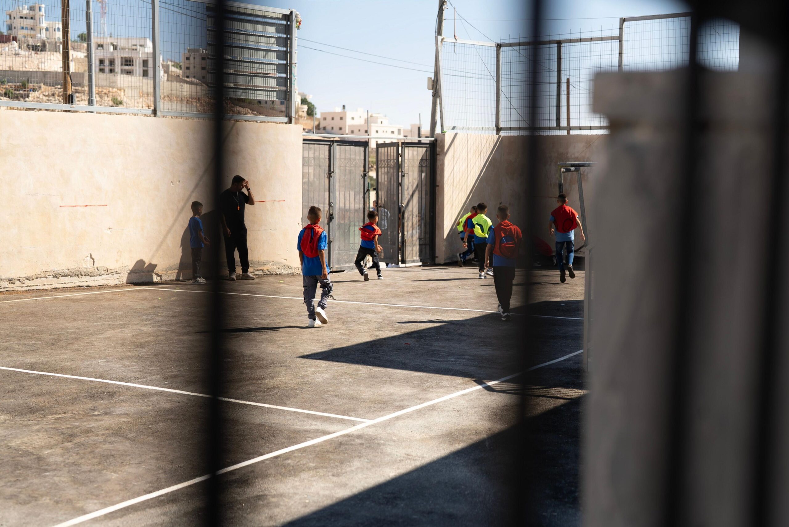 kids play football in playground.