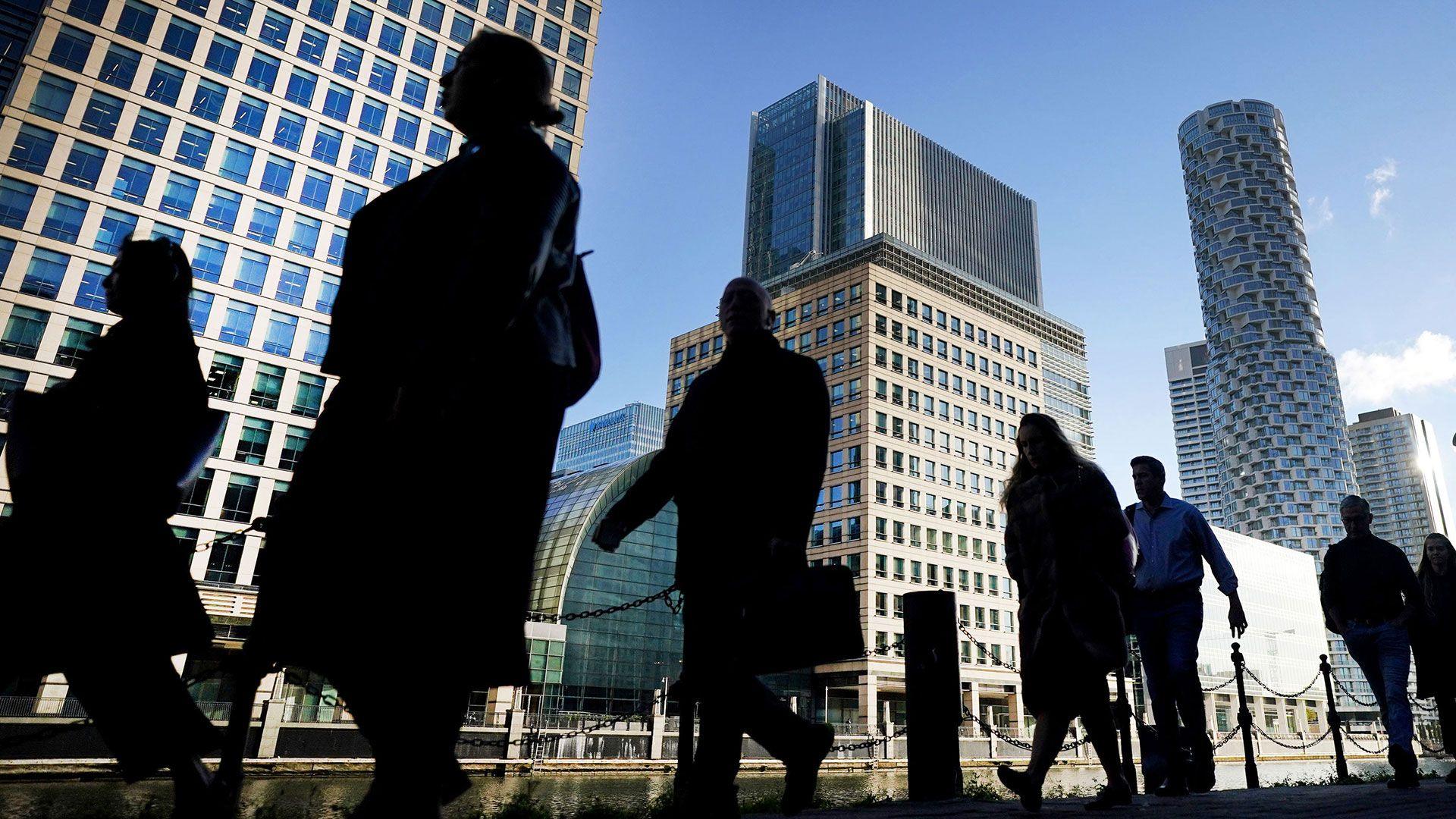 People walking in silhouette through the city