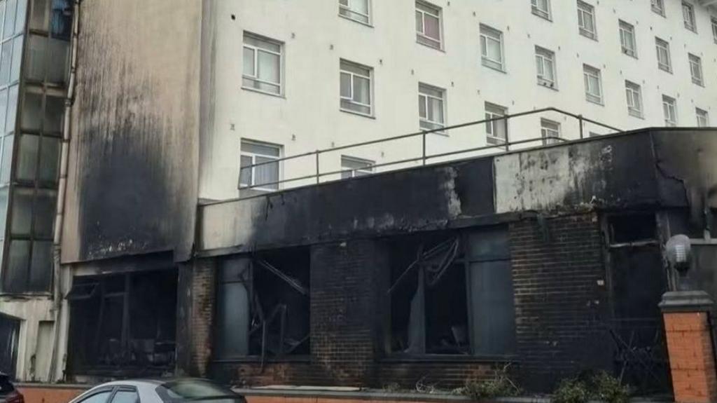 The front of a hotel damaged by fire.