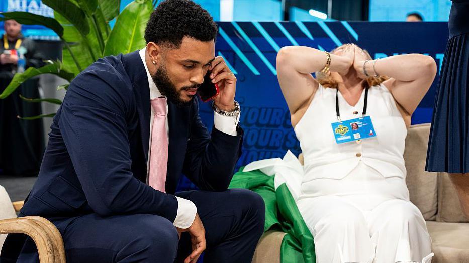 Seydou Traore takes the phone call at the NFL Draft while his mum covers her face in joy
