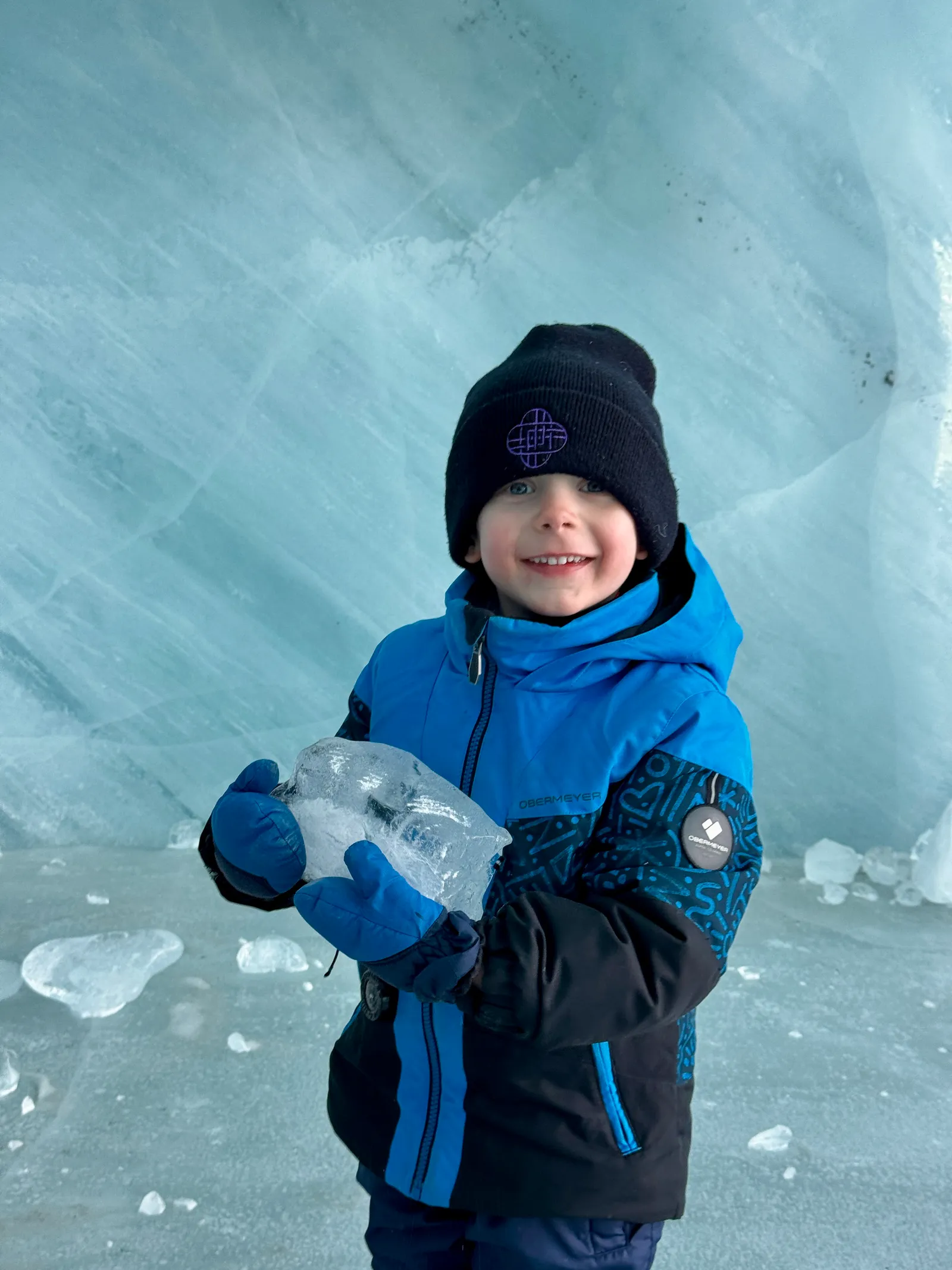 Image may contain Ice Clothing Coat Jacket Face Head Person Photography Portrait Outdoors Nature Glove and Baby