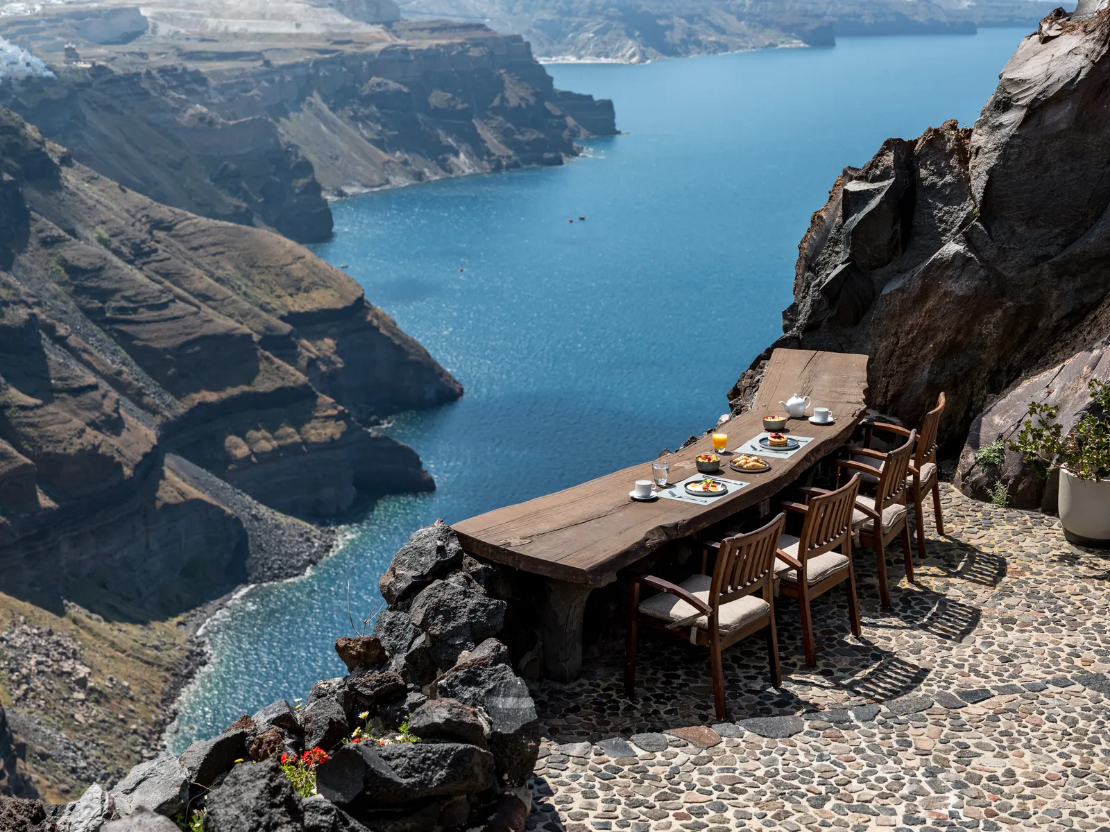 Image may contain Nature Outdoors Scenery Chair Furniture Rock Water Table Sea Cup Plate Brunch and Food
