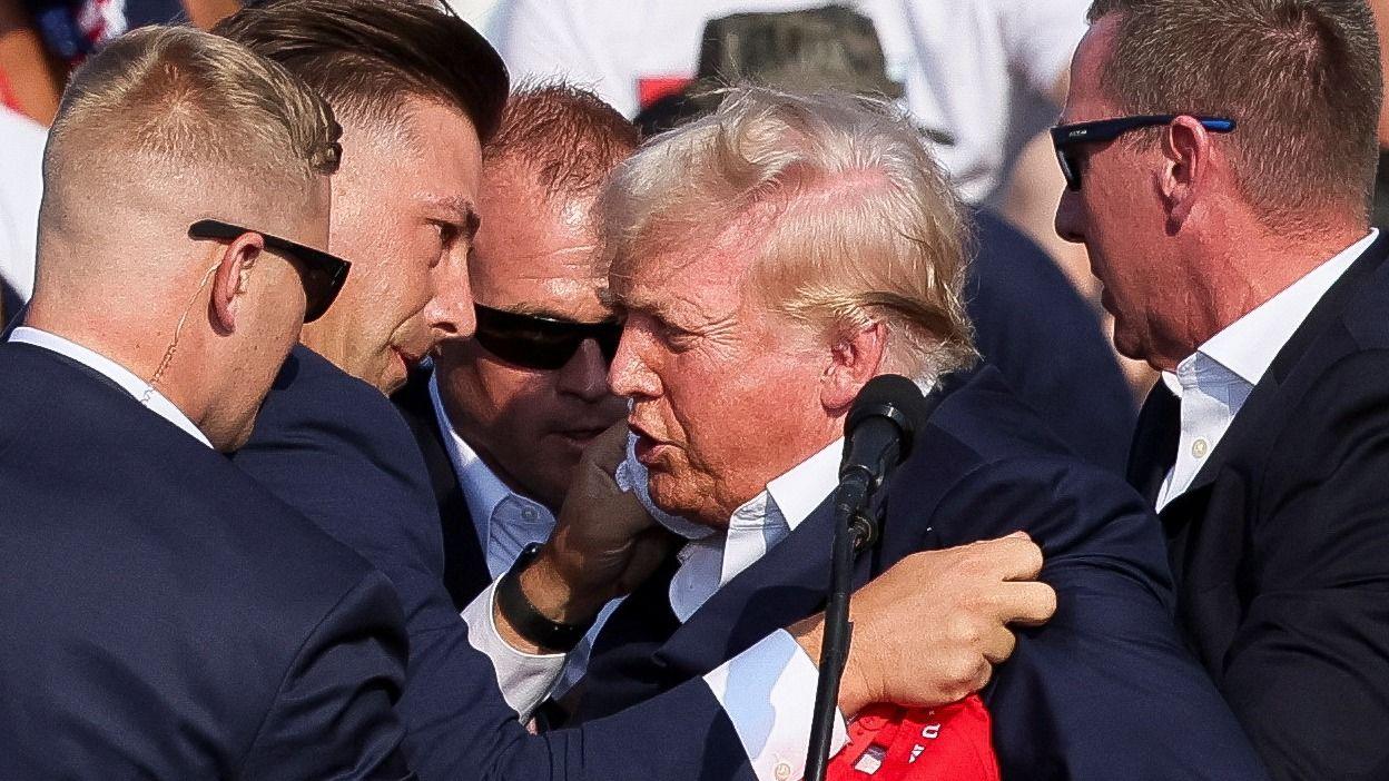 Donald Trump is assisted by Secret Service agents after being shot at
