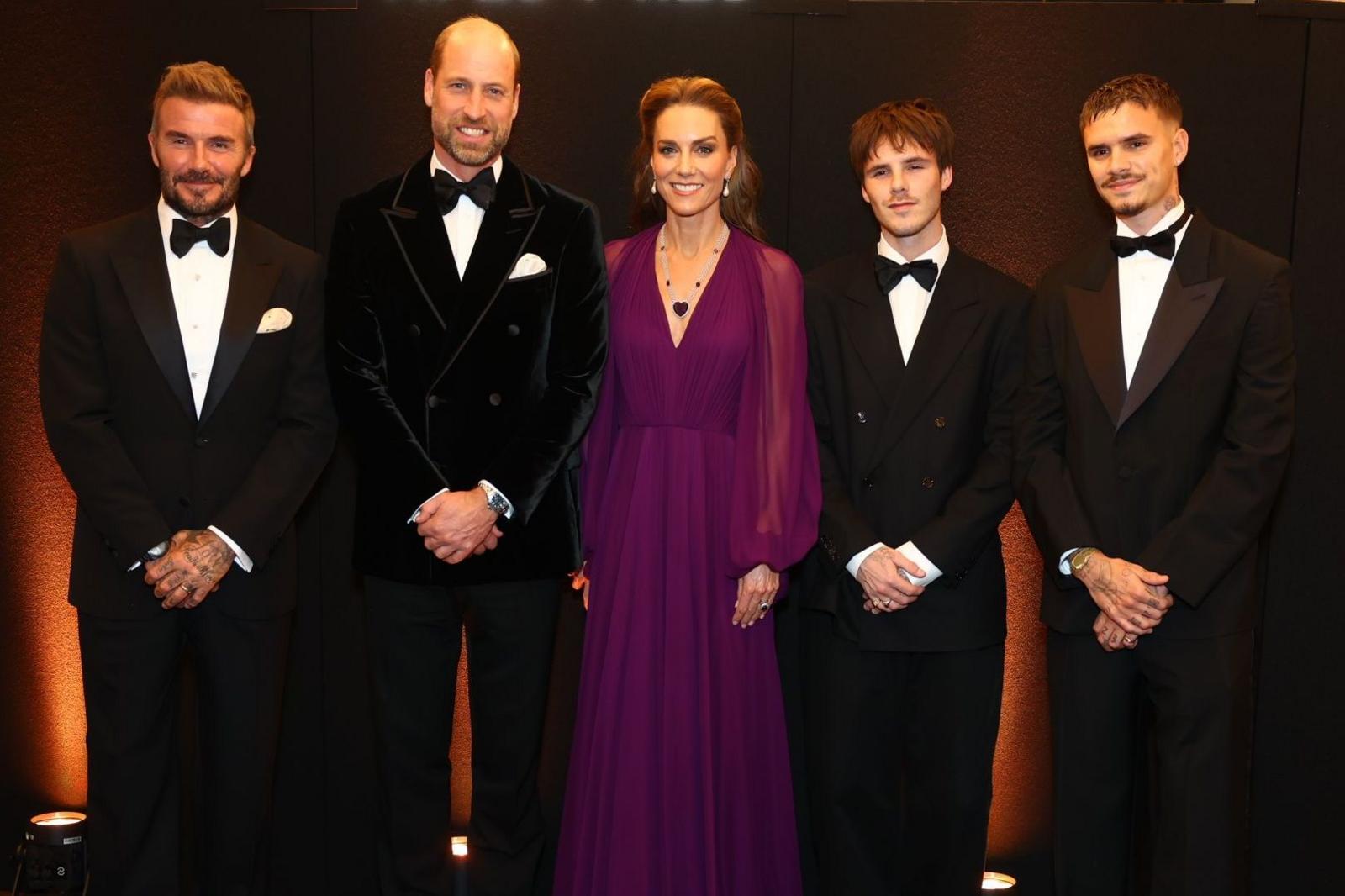 David Beckham, the Prince and Princes of Wales, Cruz Beckham and Romeo Beckham standing and posing in a row