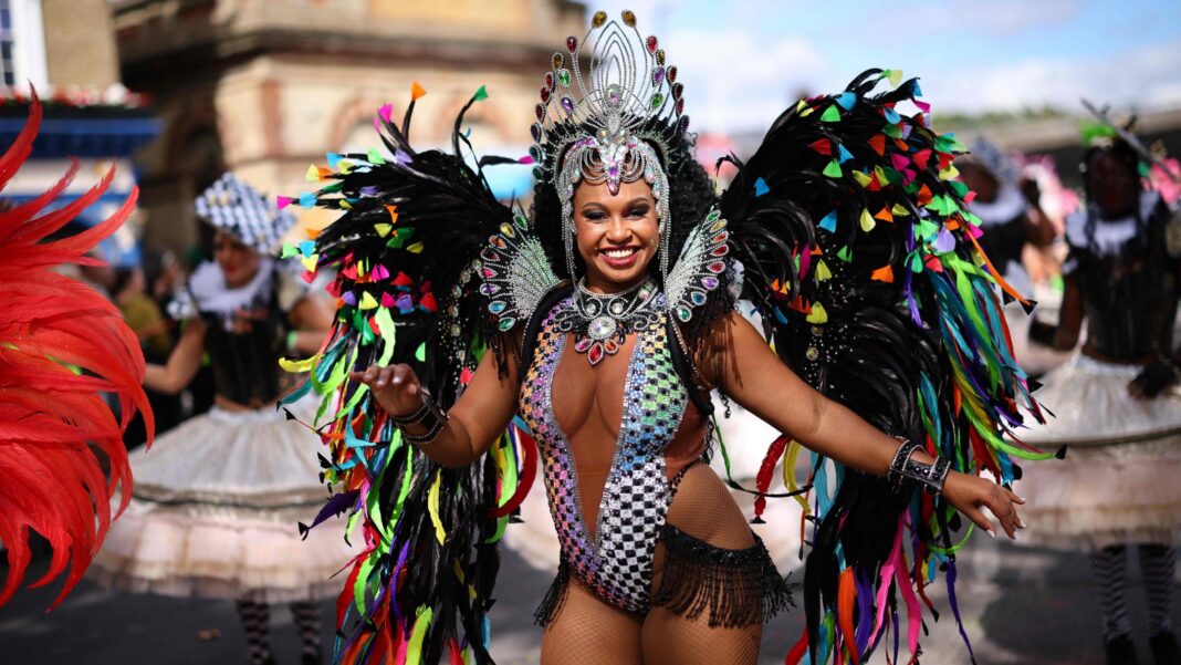 Man who died near Notting Hill Carnival is named A woman in a colourful costume with feathers