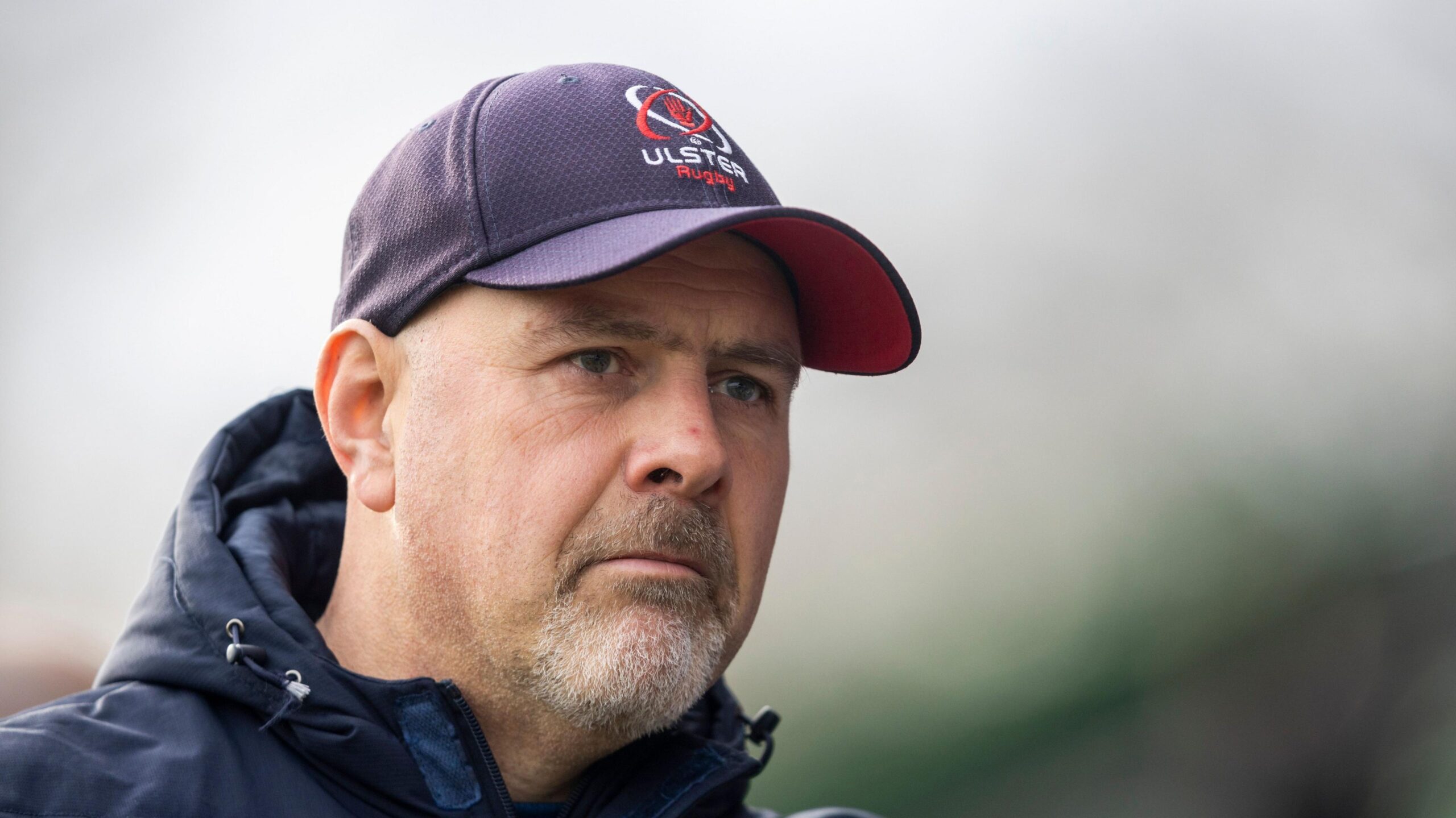 Dan McFraland wearing a navy puffa coat and a navy Ulster Rugby cap