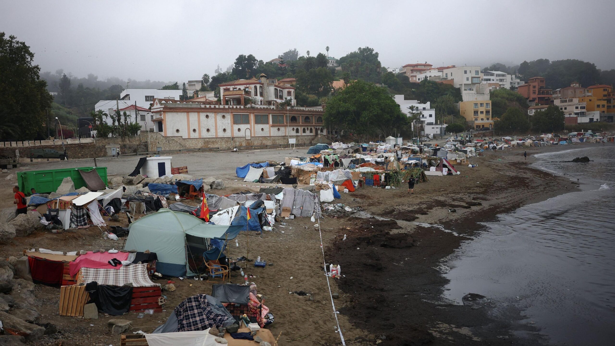 Tents along the Trampolin Beach in Ceuta on a cloudy day.
