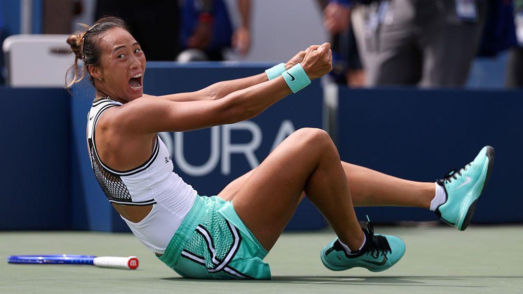 Qinwen Zheng falls to the ground in celebration after beating Madison Keys