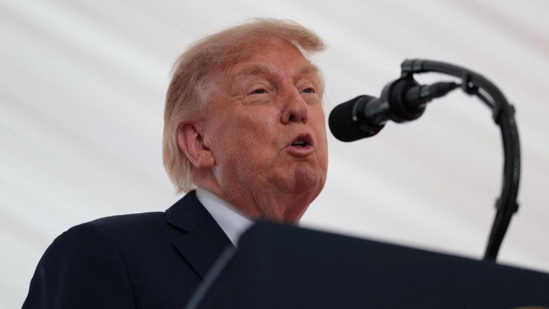 A united Ireland would be ‘fantastic’ says Trump during Irish visit Trump is speaking into a mic. He has a black suit on with a white shirt. A white backdrop is behind him.