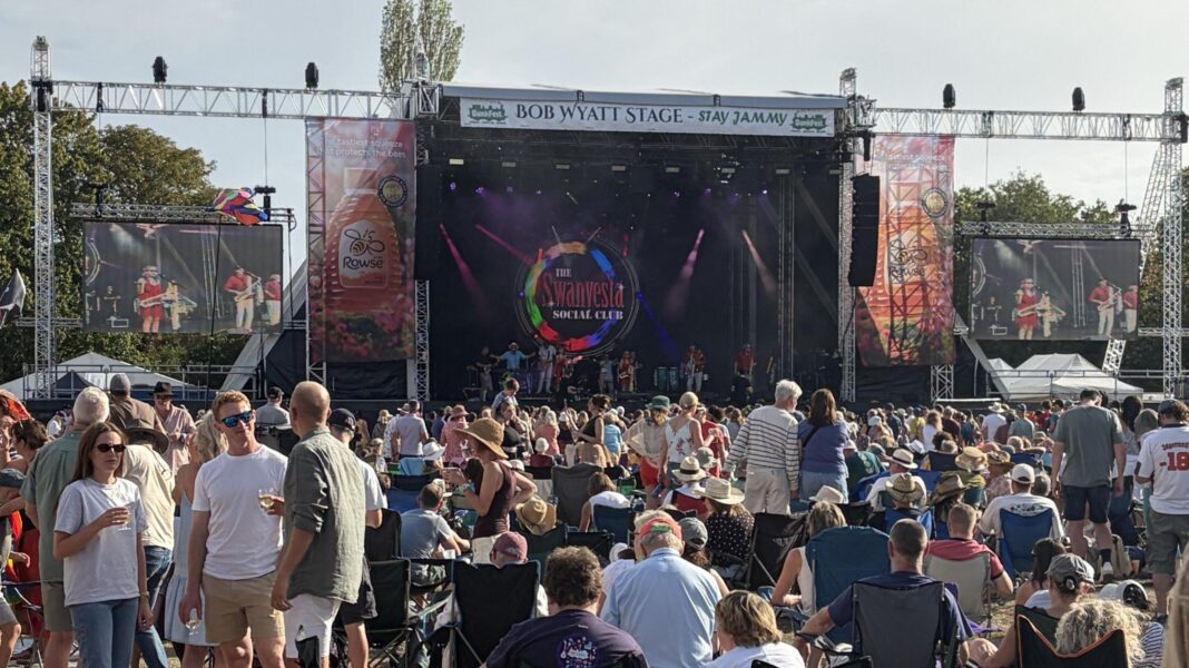 The stage of BunkFest, with screens either side, and a large crowd watching on.