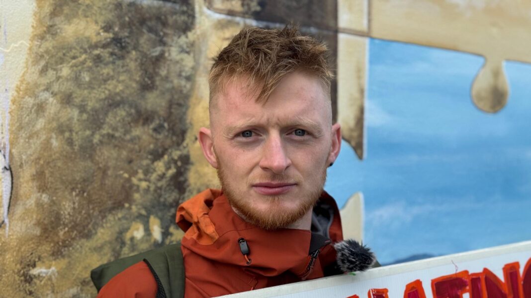 Trump says united Ireland would be ‘fantastic’ during visit to Dublin Man with blonde hair, red coat holding a sign.