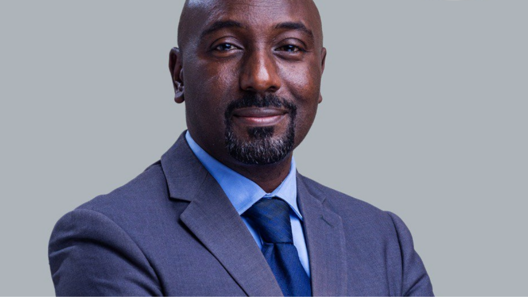 Edward Rukidi Kijanangoma wearing a dark suit and tie smiling