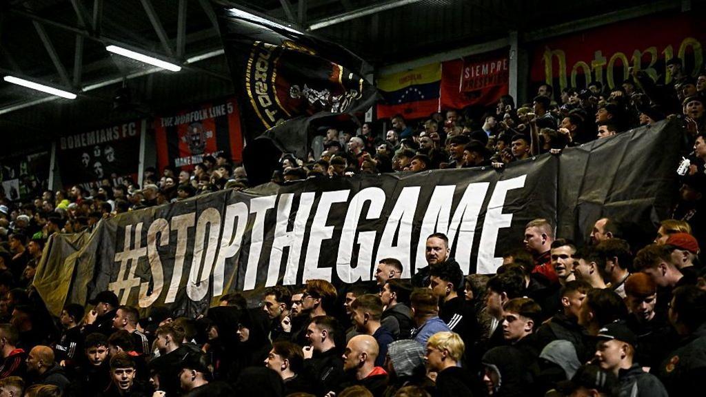 Fans of Irish Premier Division club Bohemians hold a banner reading 'Stop the Game' during a league match against Drogheda United