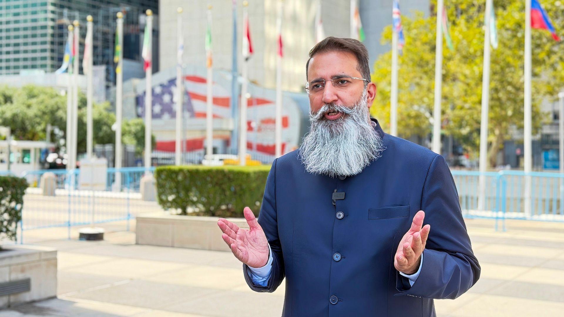 Bhuwan Ribhu, wearing dark blue suit as he stande outside the UN building in New York, US