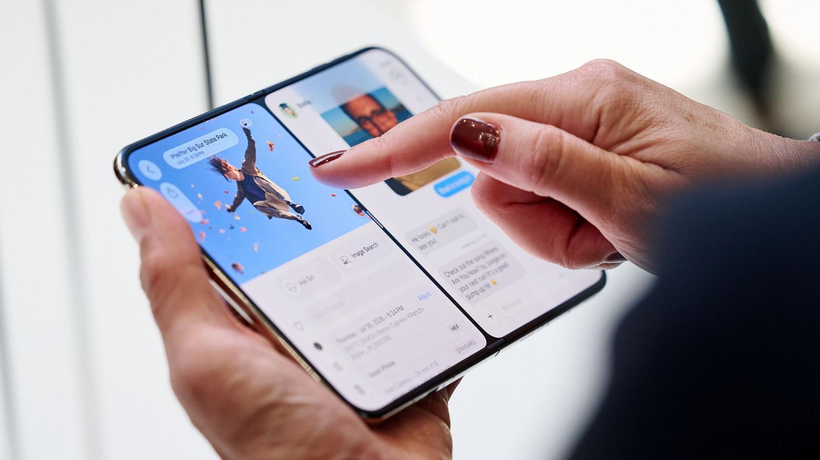 A close up shows a person's hands touching the new flip-over phone at the launch event in Cupertino.