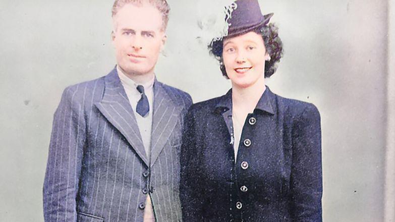 Ted and Maureen Sweeney in smart suits, smiling in a photo from 1946