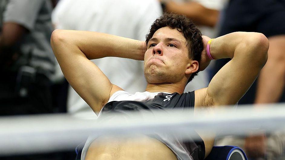 A reflective Ben Shelton sits back on his chair after losing the 2026 US Open final